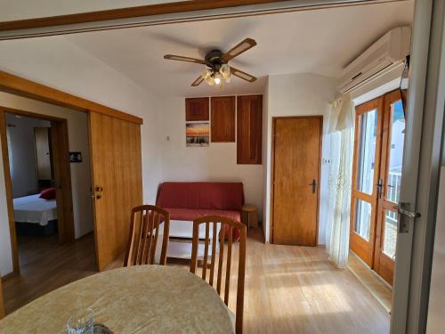 a kitchen and dining room with a table and a ceiling fan at Apartmani ROVINJEZ Komiza in Komiža