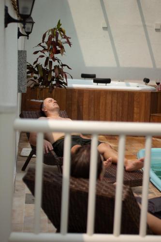 a man laying on a bed in a room at Pousada Velas do Forte in Cabo Frio