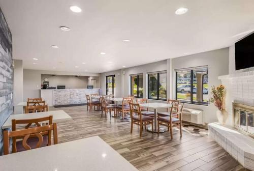 a restaurant with tables and chairs and a fireplace at Sonesta Essential Des Moines in Des Moines