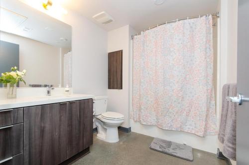 een badkamer met een toilet, een wastafel en een douchegordijn bij Adorable 2bed Apt Balcony & Rooftop Pool D in Los Angeles