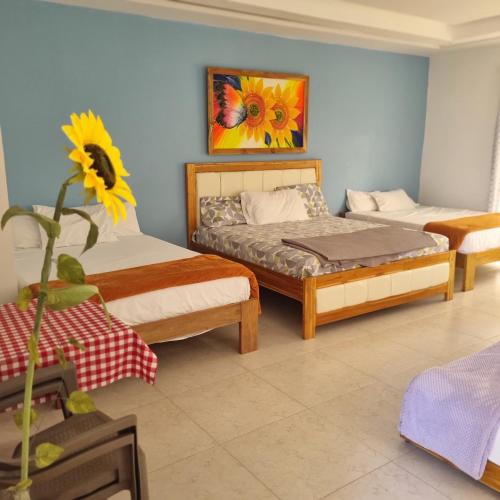 a bedroom with two beds and a vase with a flower at Dreimar Hotel Boutique in Cartagena de Indias