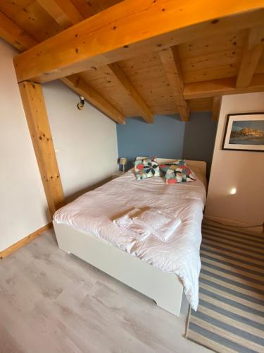 a bedroom with a bed in a room with wooden ceilings at Charming Chalet in Passy in Passy