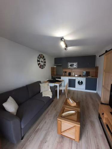 un salon avec un canapé et une table dans l'établissement Appartement en rez-de jardin à 50m de la mer!, à Villers-sur-Mer