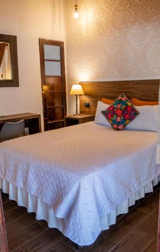 a bedroom with a large white bed in a room at Hotel Las Camelias Inn by AHS in Antigua Guatemala
