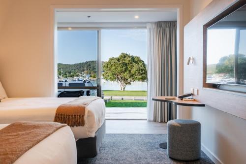 a hotel room with two beds and a large window at Copthorne Hotel & Resort Bay Of Islands in Paihia