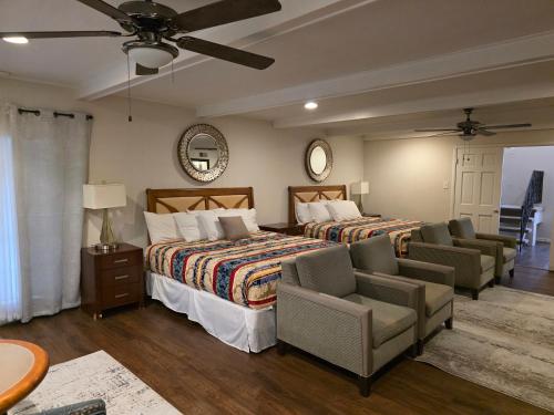 1 Schlafzimmer mit 2 Betten und Stühlen sowie einem Deckenventilator in der Unterkunft Luxury Southern Mansion w/ Pool in Memphis