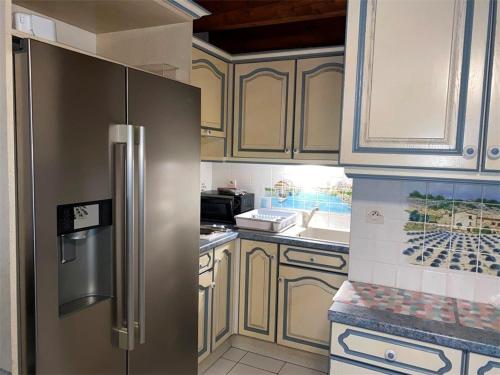 une cuisine avec un réfrigérateur et des armoires en acier inoxydable dans l'établissement Maison Provençale avec Piscine, Jardin et Terrasse, Parking Privé, 4-6 Pers. au Grau-du-Roi - FR-1-731-95, au Grau-du-Roi