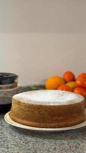 a cake on a plate next to a pile of fruit at Casa Rural Abreu Do Louro in Arbo