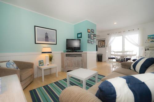a living room with a couch and a tv at The Montauk Soundview in Montauk