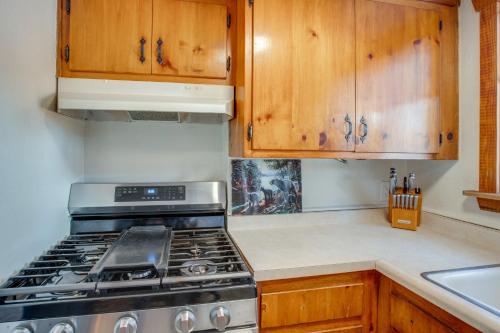 a kitchen with a stove and wooden cabinets at Walk to Beach Dog-Friendly Cabin in Glenbrook! in Glenbrook