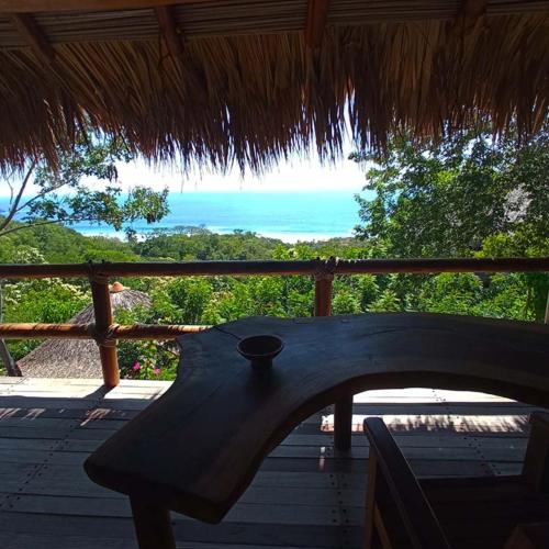 a bench on a porch with a view of the ocean at Zazil Retreat in San Agustinillo