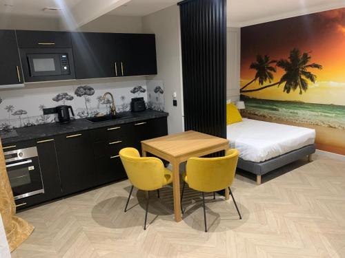 Il comprend une cuisine et une chambre avec un lit, une table et des chaises. dans l'établissement Les Ecuries du Roi - Château Versailles-Parking-Wifi-Netflix, à Villepreux