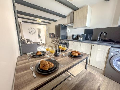une cuisine avec une table et des verres de jus d'orange dans l'établissement Le Cocon Appartement a 300m du Théâtre Antique, à Orange