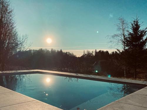 - une piscine avec la lune dans le ciel dans l'établissement Lodge du Monthury, à Servance