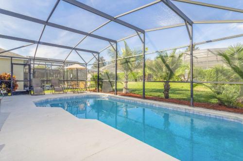 a swimming pool in a glass house with a swimming poolvisor at Villa Helena, Windsor Palms in Kissimmee