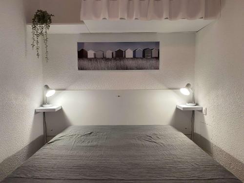 - une chambre dotée d'un lit avec deux lumières dans l'établissement T1 avec terrasse, parking & climatisation à Balaruc-les-Bains - FR-1-553-283, à Balaruc-les-Bains