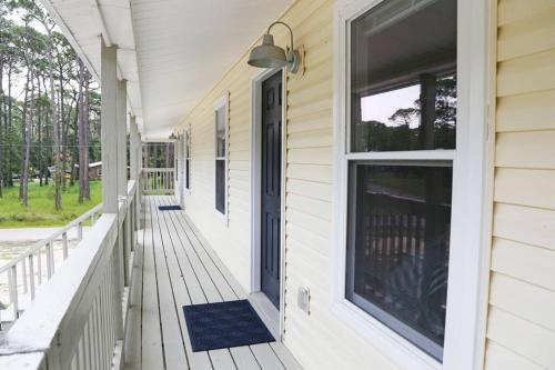 a front porch of a house with a blue door at Gulf Coast Condos on the Sand Dunes - 201 in Dauphin Island