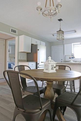 a dining room table with chairs and a kitchen at Gulf Coast Condos on the Sand Dunes - 201 in Dauphin Island