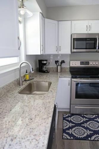 a kitchen with a sink and a stove at Gulf Coast Condos on the Sand Dunes - 201 in Dauphin Island