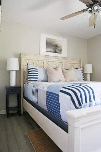 a bedroom with a bed with blue and white pillows at Gulf Coast Condos on the Sand Dunes - 201 in Dauphin Island