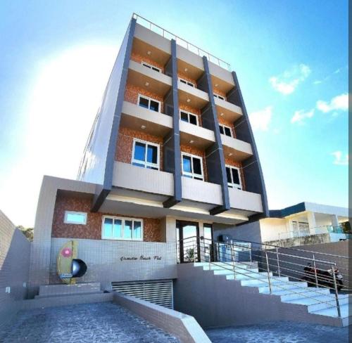 a building with a pool in front of it at Apartamento Beira Mar de João Pessoa PB in João Pessoa