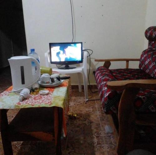 a living room with a tv and a table with a coffee table sidx sidx at Brikama line house in Brikama