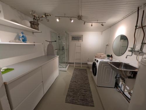 a bathroom with a sink and a washing machine at Koselig kjellerleilighet, gratis parkering! in Trondheim