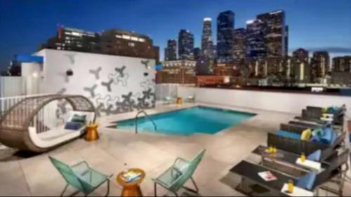 a pool on top of a building with a city skyline at Lovely 3BR Apt With Balcony And Rooftop Pool Plus Views in Los Angeles