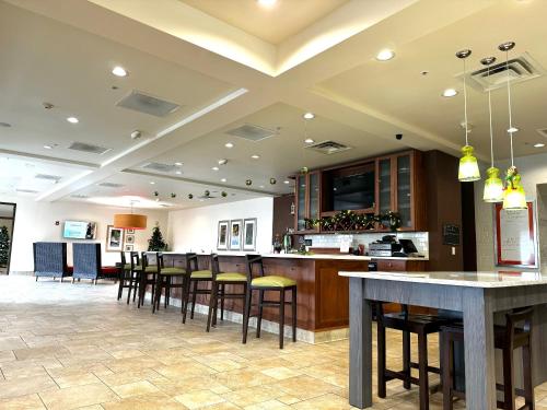 a large kitchen with a bar with stools at Hilton Garden Inn West Chester in West Chester