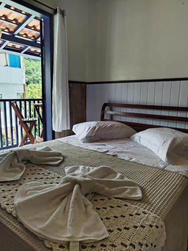 a bedroom with two beds with towels on them at Pouso Trindade in Trindade