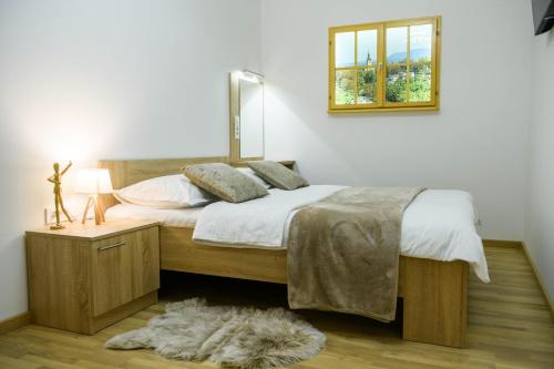 a bedroom with a bed and a window and a rug at Apartmani Petra i Tea in Krapina
