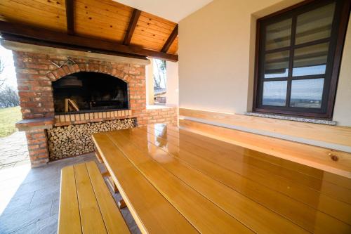 a porch with a fireplace and a wooden bench at Apartmani Petra i Tea in Krapina