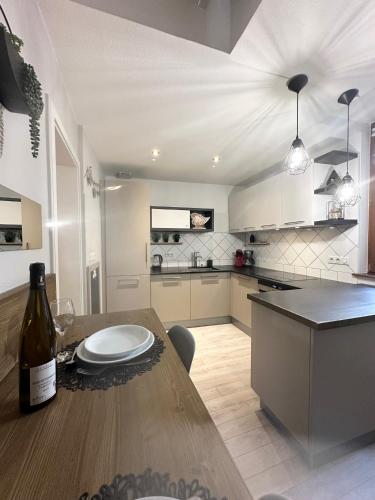 - une cuisine avec une table et une bouteille de vin dans l'établissement Jeannette, à Ribeauvillé