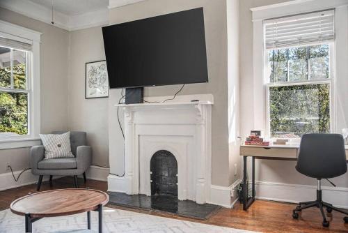 a living room with a fireplace with a tv on the wall at Old Dauphin Way Historic Home - Unit 2 in Mobile