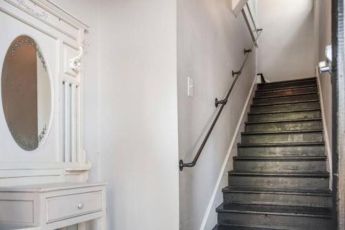 a hallway with a staircase with a mirror and a mirror at Old Dauphin Way Historic Home - Unit 2 in Mobile