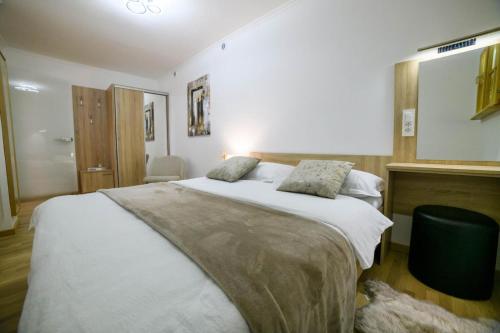 a bedroom with a large bed with white sheets at Apartmani Petra i Tea in Krapina