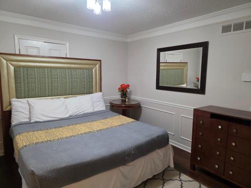 a bedroom with a bed and a dresser and a mirror at Modern Vast Southern Home with Pool Near Shops in Memphis