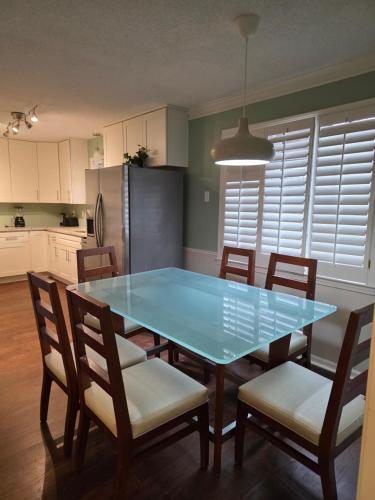 a kitchen with a table with chairs and a refrigerator at Modern Vast Southern Home with Pool Near Shops in Memphis