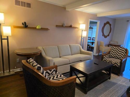 a living room with a couch and chairs and a table at Modern Vast Southern Home with Pool Near Shops in Memphis