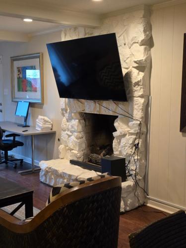 a stone fireplace with a tv on top of it at Modern Vast Southern Home with Pool Near Shops in Memphis