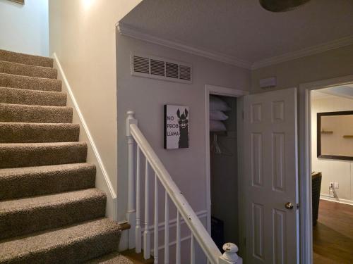 a staircase in a home with a white door at Modern Vast Southern Home with Pool Near Shops in Memphis