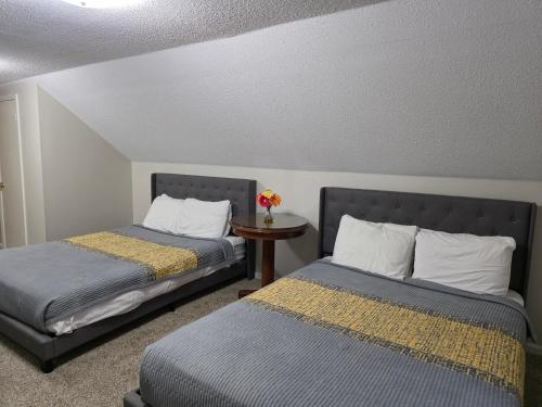 two beds sitting next to each other in a room at Modern Vast Southern Home with Pool Near Shops in Memphis