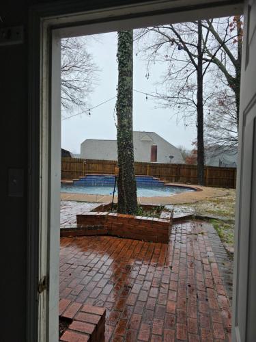 a door leading into a yard with a tree at Modern Vast Southern Home with Pool Near Shops in Memphis