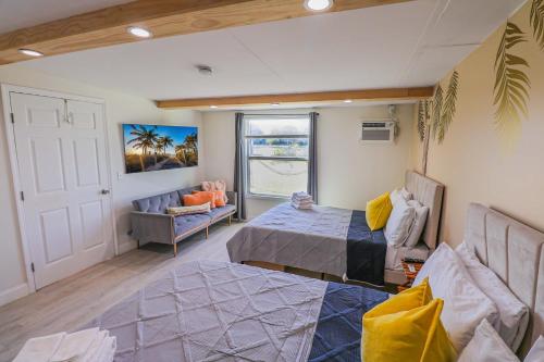 a bedroom with a bed and a couch and a window at BRANDNEW 2023 LAKEFRONT APT in Kissimmee