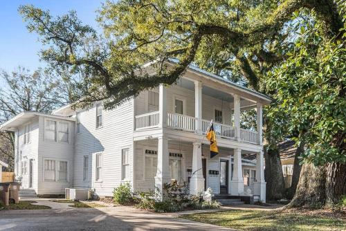 une maison blanche avec un arbre devant dans l'établissement Old Dauphin Way Historic Home - Unit 5, à Mobile