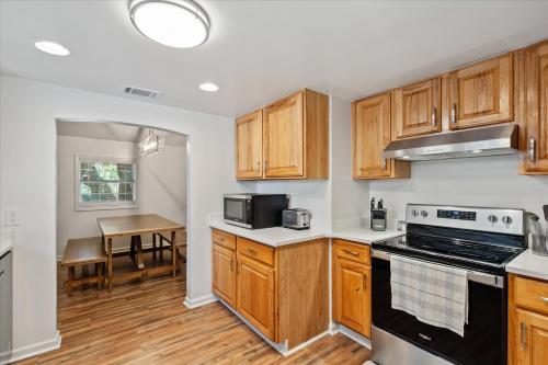 a kitchen with wooden cabinets and a dining room with a table at Quaint Family Getaway on Biloxi in Dauphin Island