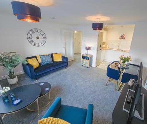 a living room with a blue couch and a table at Kilmartin Court Apartments - No3 By The Sea & No2 With A View - free parking in Oban