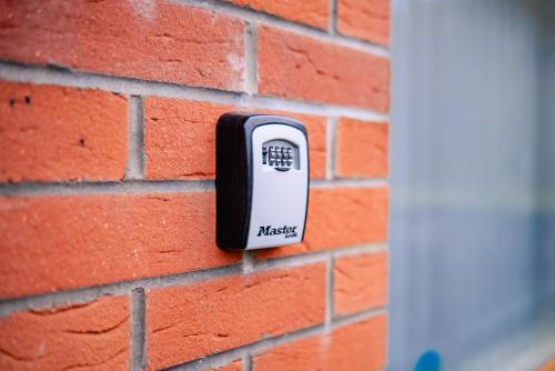 a brick wall with an electric socket on it at Bright & Elegant House Near City Centre and Stadium in Cardiff