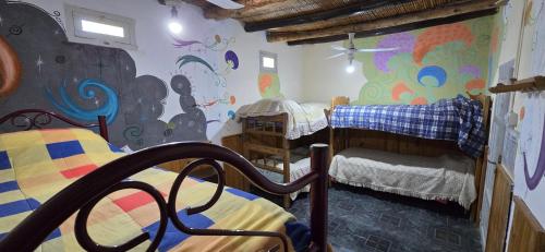 a room with two bunk beds and a mural at Posada del Valle in San Agustín de Valle Fértil