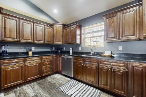 a kitchen with wooden cabinets and black counter tops at Hatters Hide A Way in Kodak